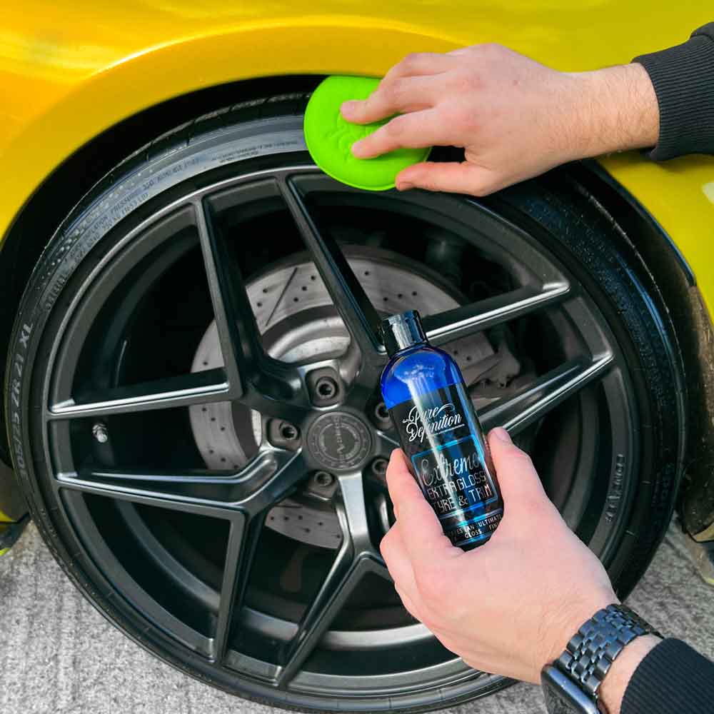 applying extreme extra gloss tyre gel to car tyre