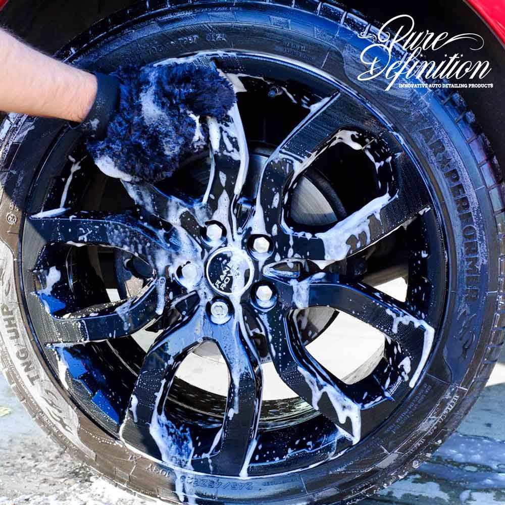 washing black Range Rover wheel with wash mitt
