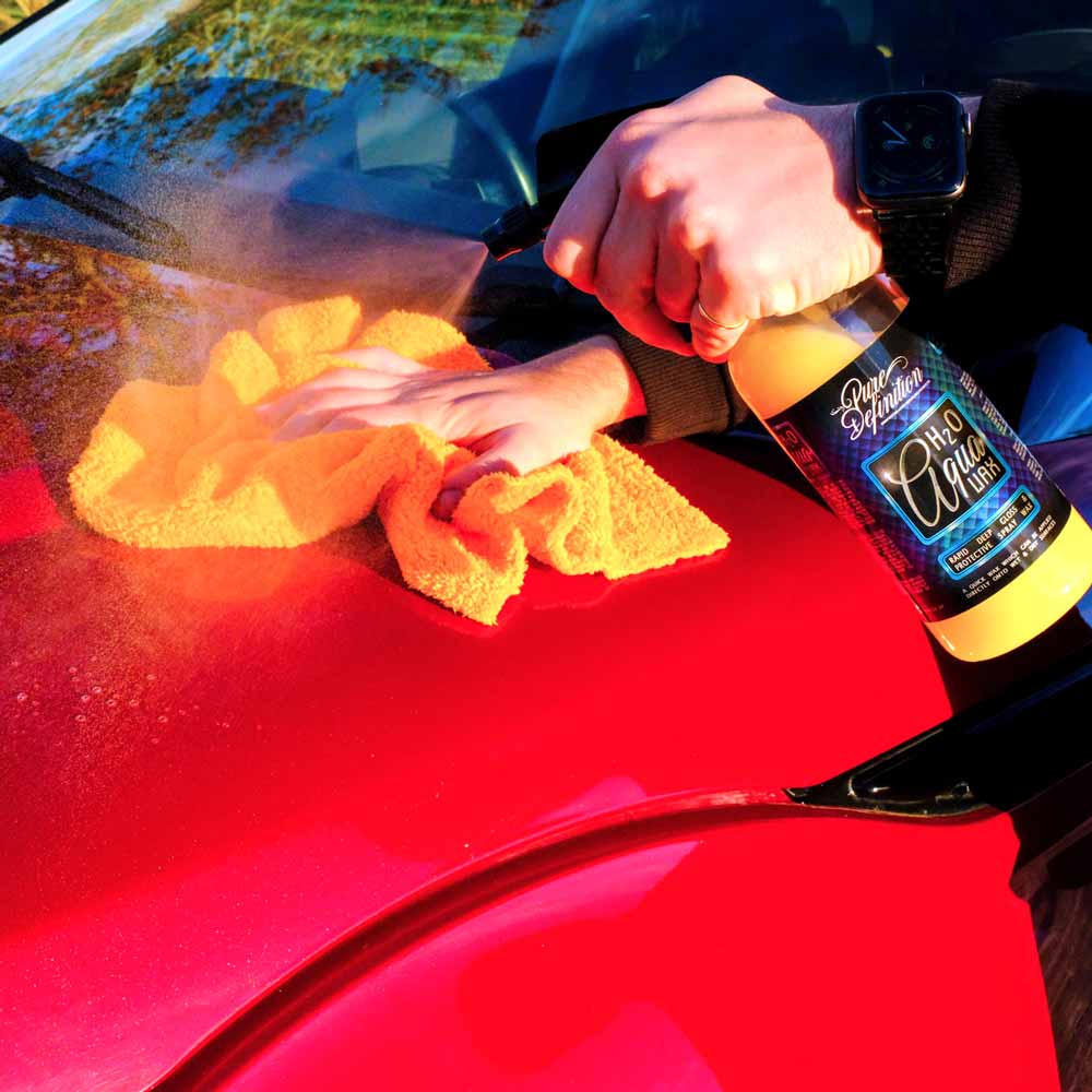 applying h20 aqua wax to the bonnet of a red Range Rover