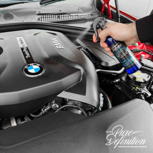 spraying tyre and trim radiant dressing onto a BMW engine bay cover