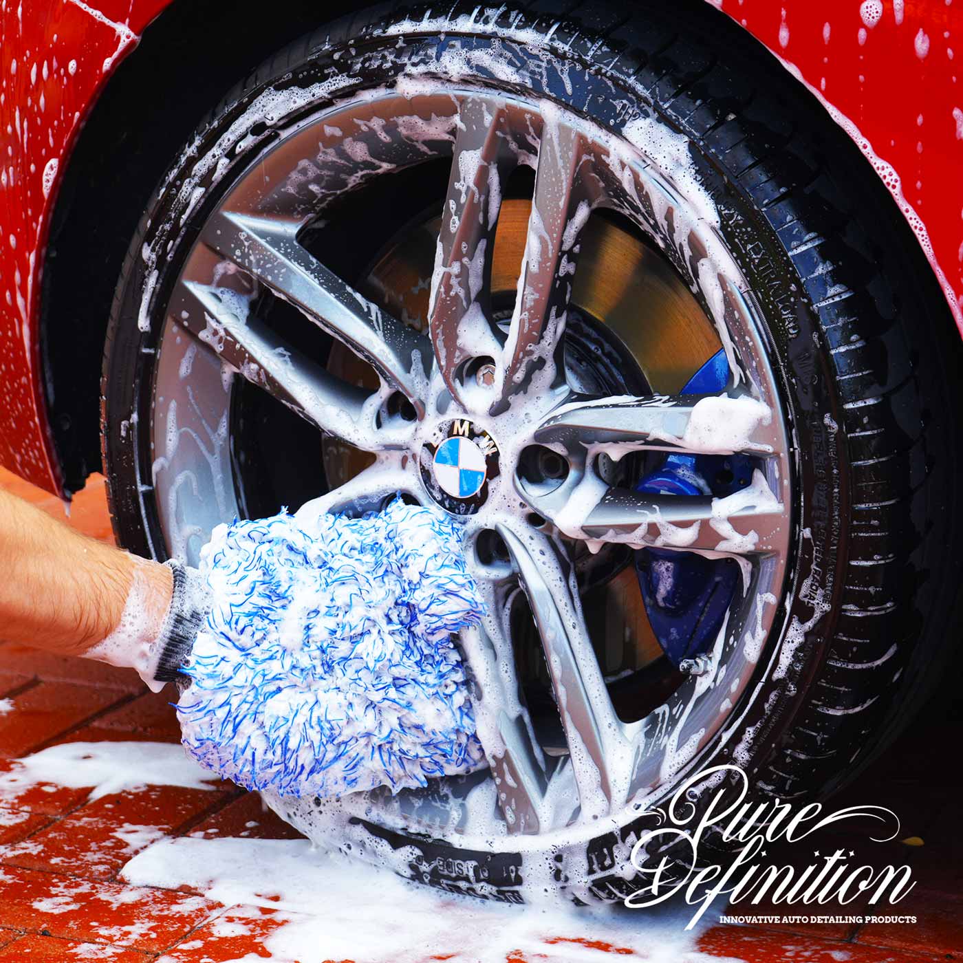 washing black Range Rover wheel with wash mitt
